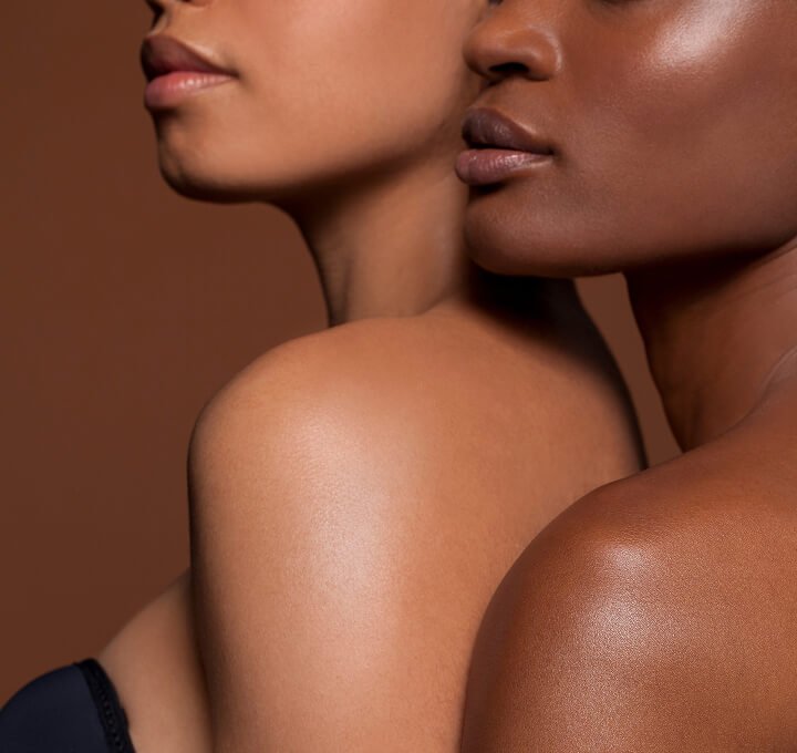 Shoulder closeup of two women with glowing skin Woman getting a head message